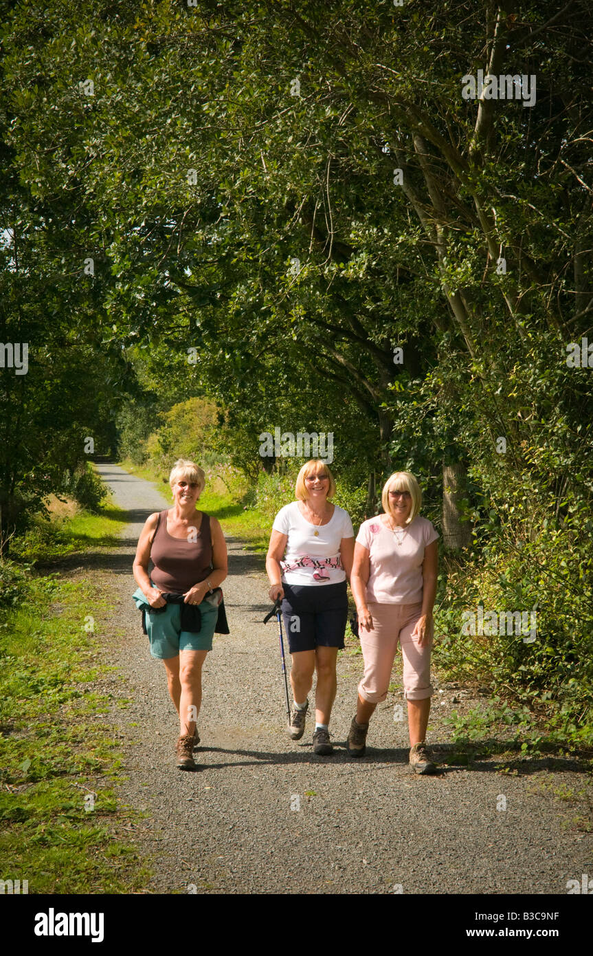 Tre sorridente bionda donne di mezza età in vacanza a piedi sul sentiero Ystwyth ciclabile, vicino a Aberystwyth Wales UK Foto Stock