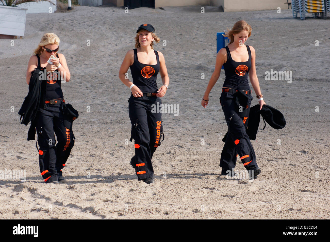 Tre donne in nero nel complesso a camminare sulla sabbia di Hoek van Holland beach in Paesi Bassi Foto Stock