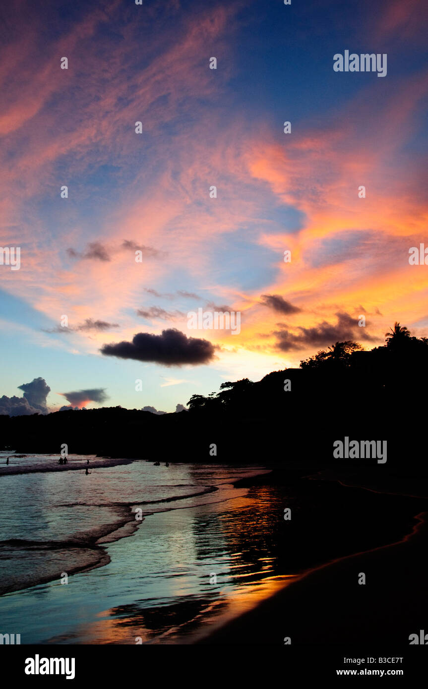 Playa la Ropa Sunset Zihuatanejo Messico // ZIHUATANEJO, Messico - il sole tramonta su Playa la Ropa, che getta sfumature dorate sulla sabbia e sull'oceano a Zihuatanejo, Guerrero, Messico. Questa famosa spiaggia è conosciuta per le sue acque tranquille e le splendide viste del tramonto, che la rendono una destinazione preferita sia dalla gente del posto che dai turisti. Foto Stock