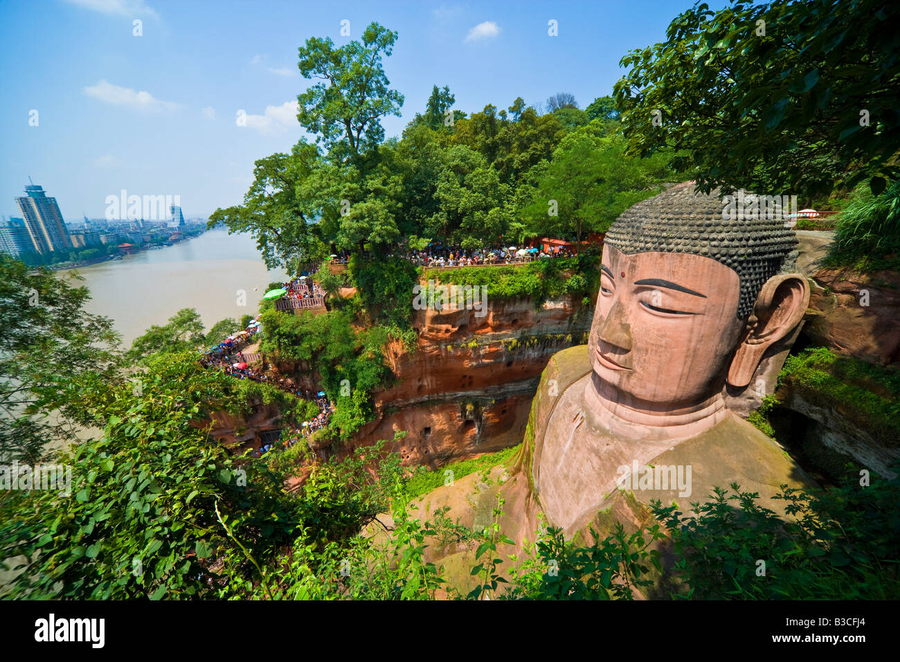 Buddha di Leshan Dafo nella provincia del Sichuan in Cina con Leshan city città sul fiume in background JMH3240 Foto Stock