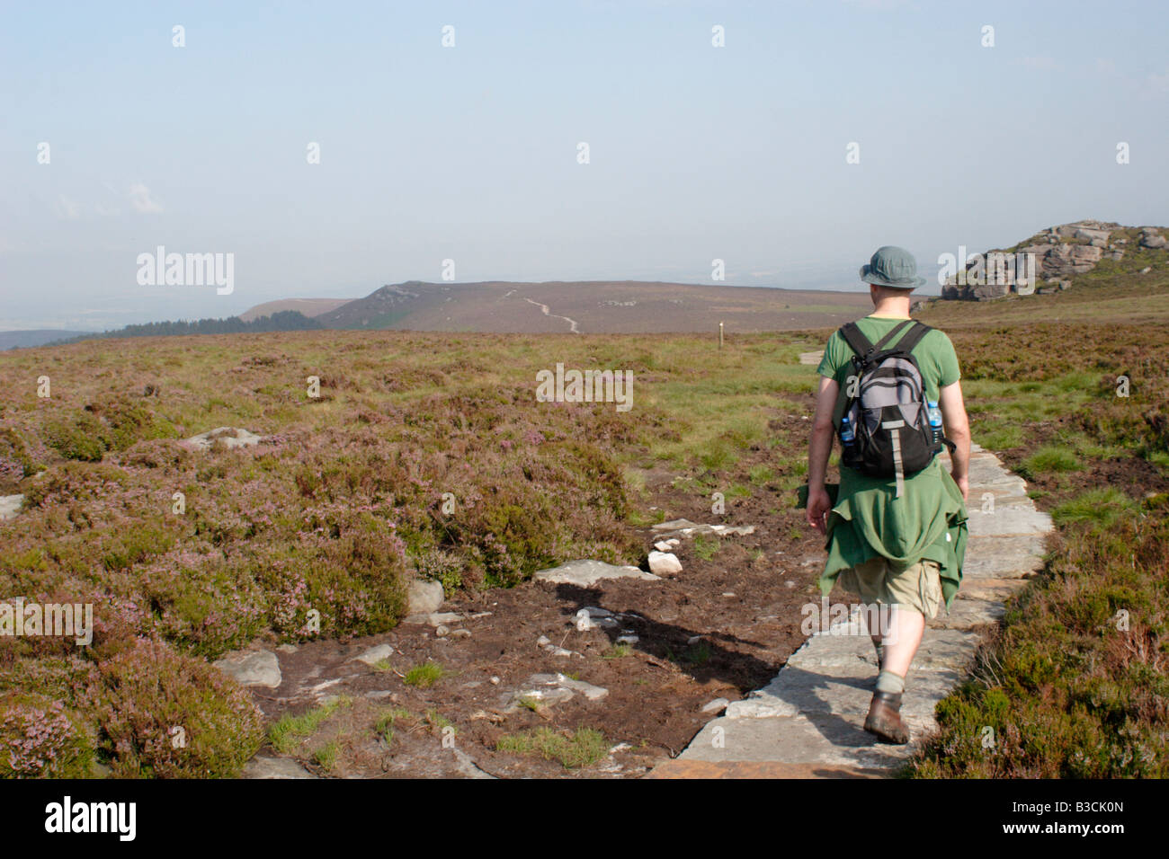 Uomo che cammina lungo la cresta Simonside a piedi, parco nazionale di Northumberland, Regno Unito Foto Stock