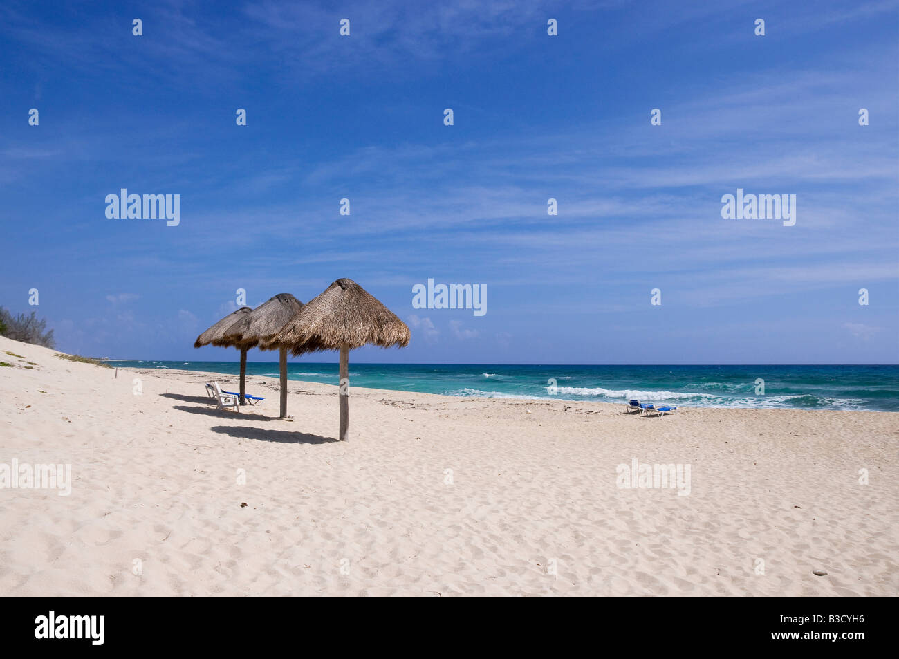 Mexiko, Cozumel, sedie a sdraio e Palapas sulla spiaggia tropicale Foto Stock