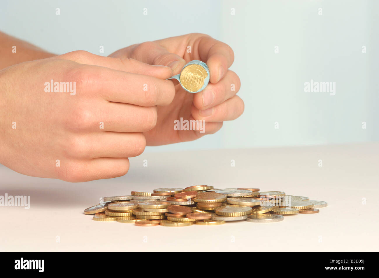 Mano azienda coin roll, close-up Foto Stock