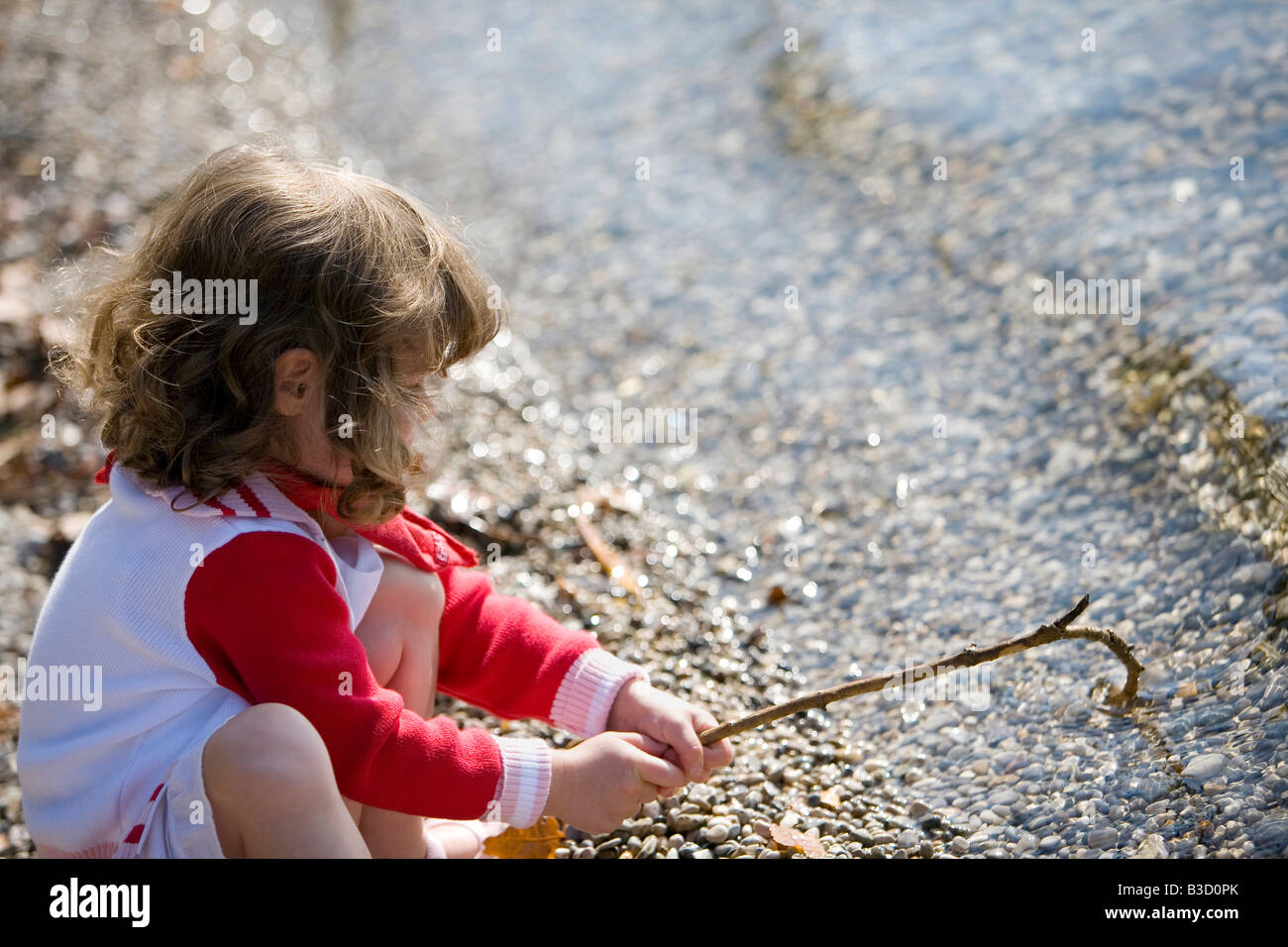 In Germania, in Baviera, Ammersee, bambina (3-4) giocando sulla spiaggia Foto Stock