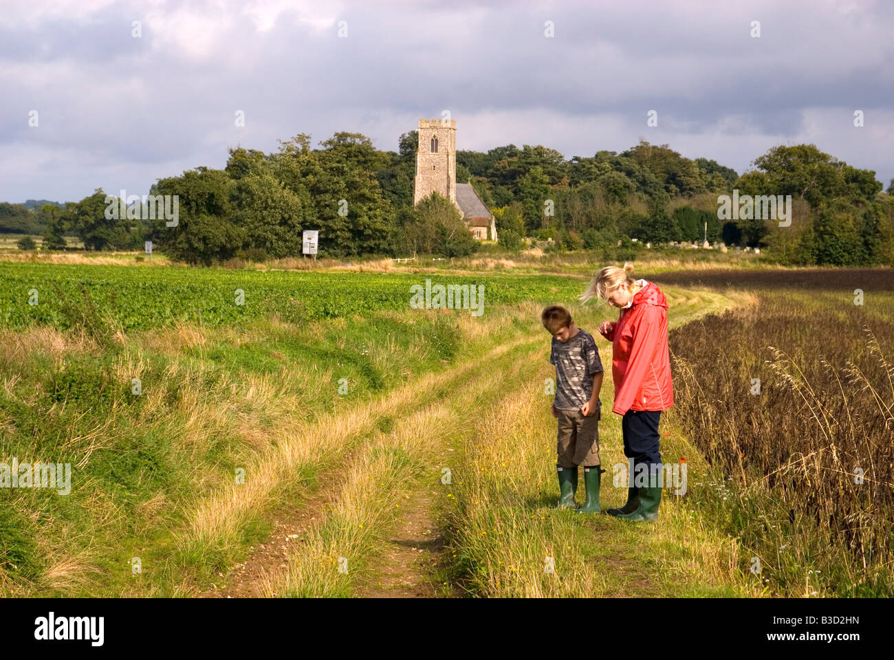 Madre e figlio guardando i fiori selvatici del paese a piedi in Henstead Suffolk REGNO UNITO Foto Stock