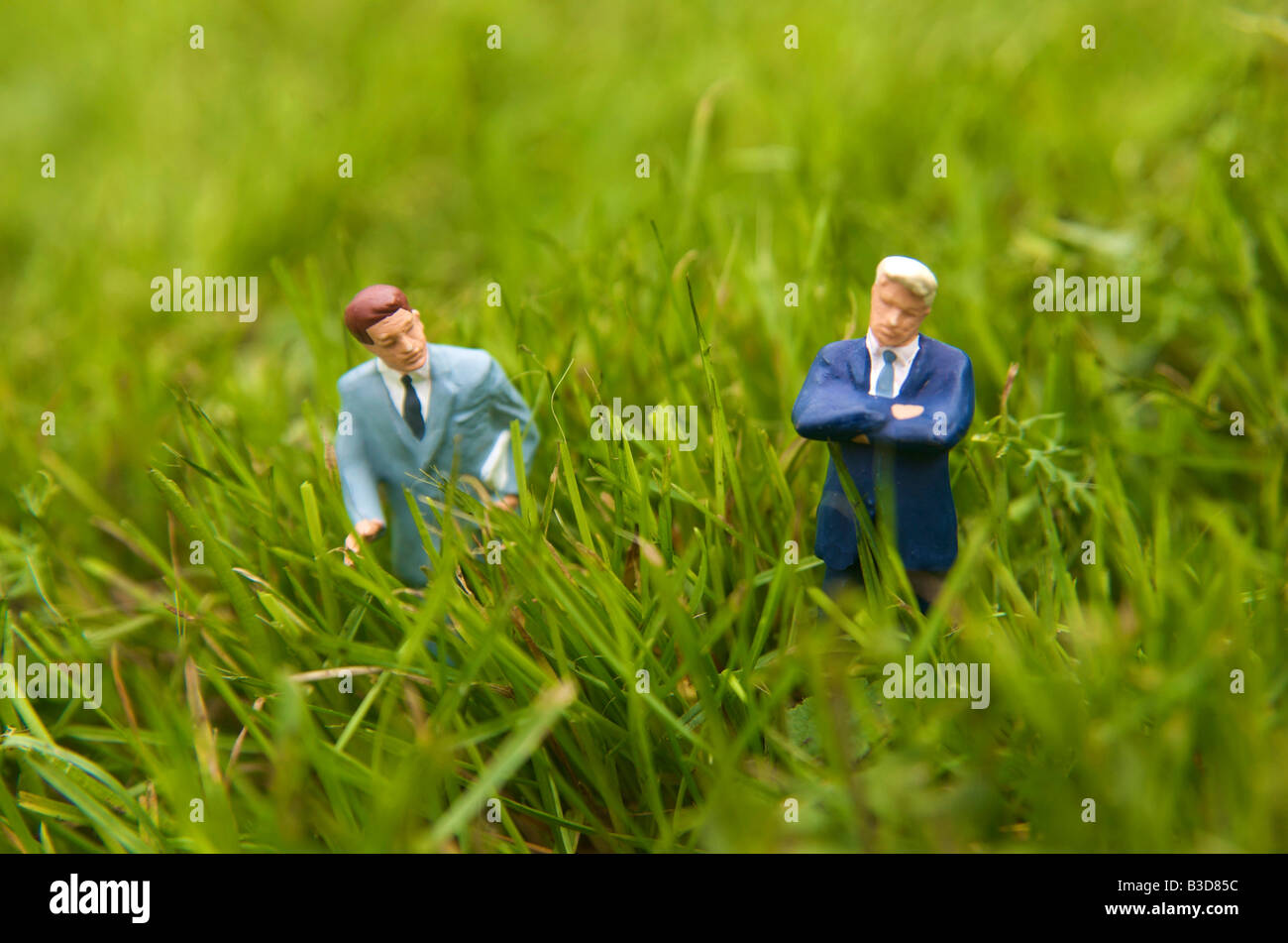 Uomini d'affari in piedi in un campo di erba - la terra di acquisto / vendita / Costruzione / consenso pianificazione / cintura verde di concetto Foto Stock
