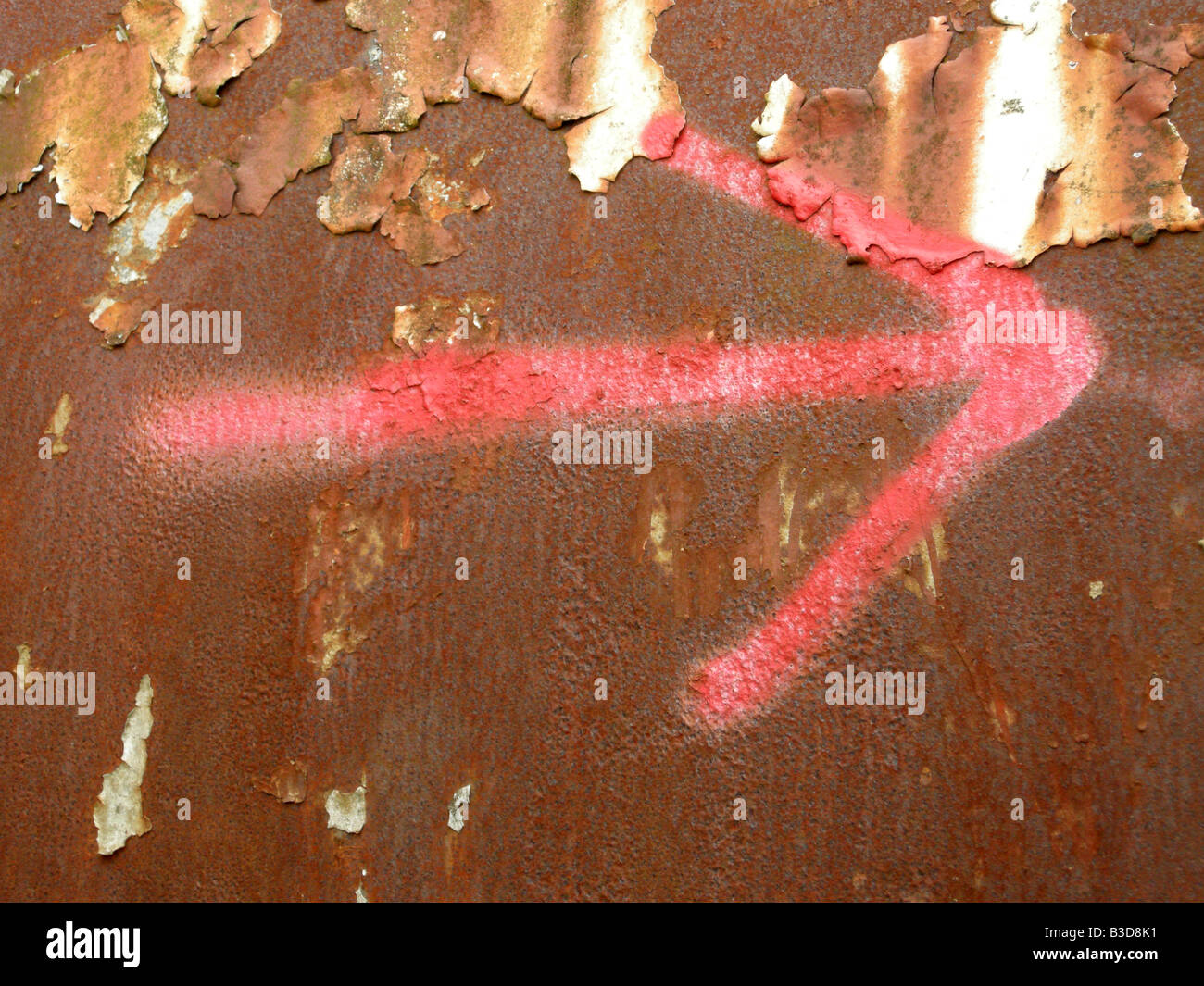 Dipinto di rosso freccia su un metallo arrugginito sfondo Foto Stock