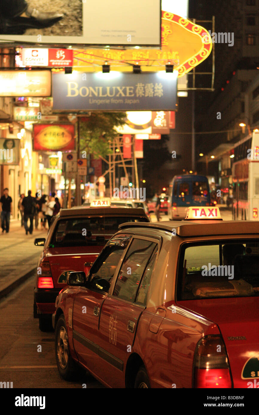 Fila di taxi sulla strada di notte a Hong Kong, Cina, Asia Foto Stock