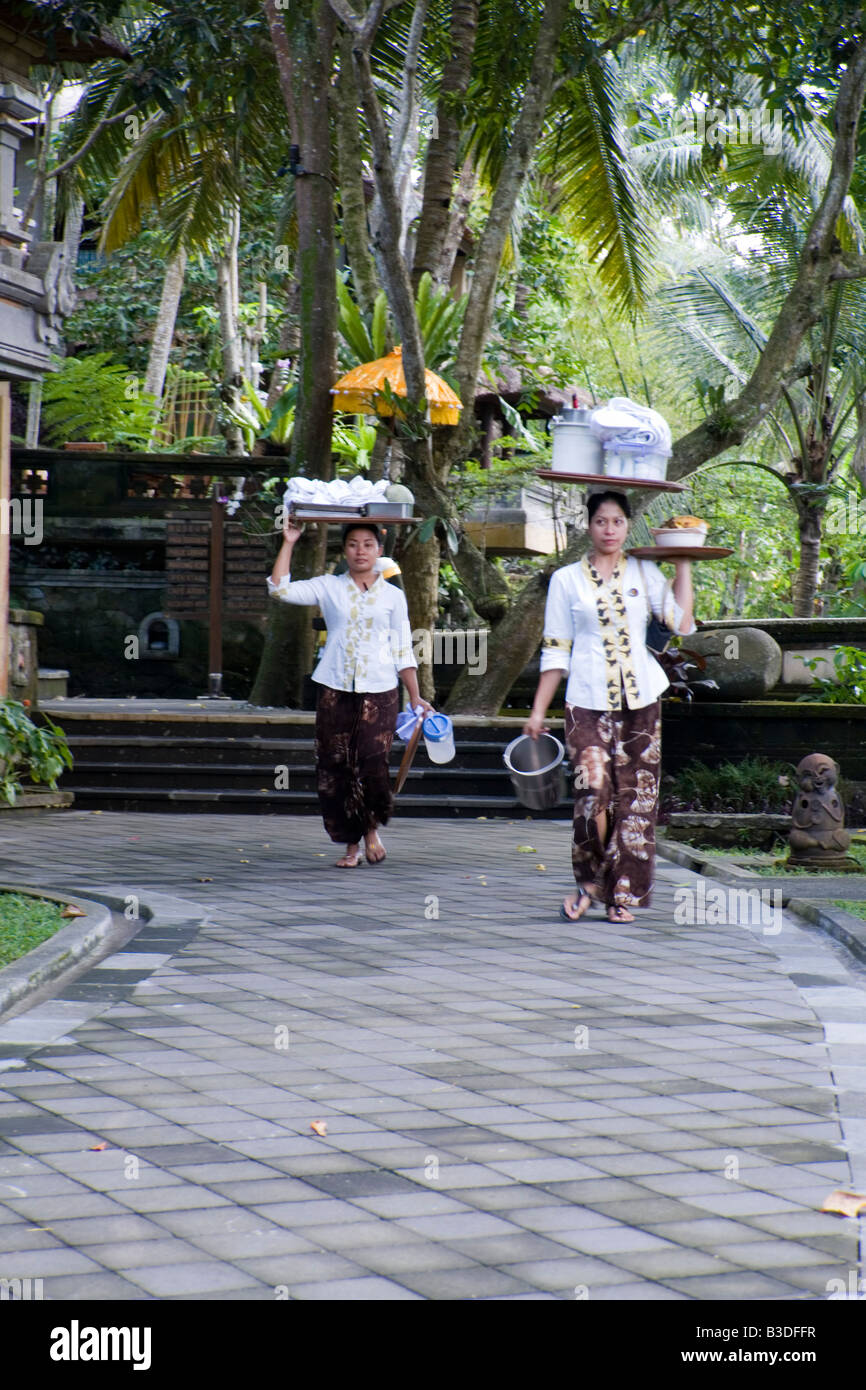 Interno indonesiano dipendenti indossando carichi sulla loro testa (Bali). Employées de maison portant une caricare sur la tête (Bali). Foto Stock
