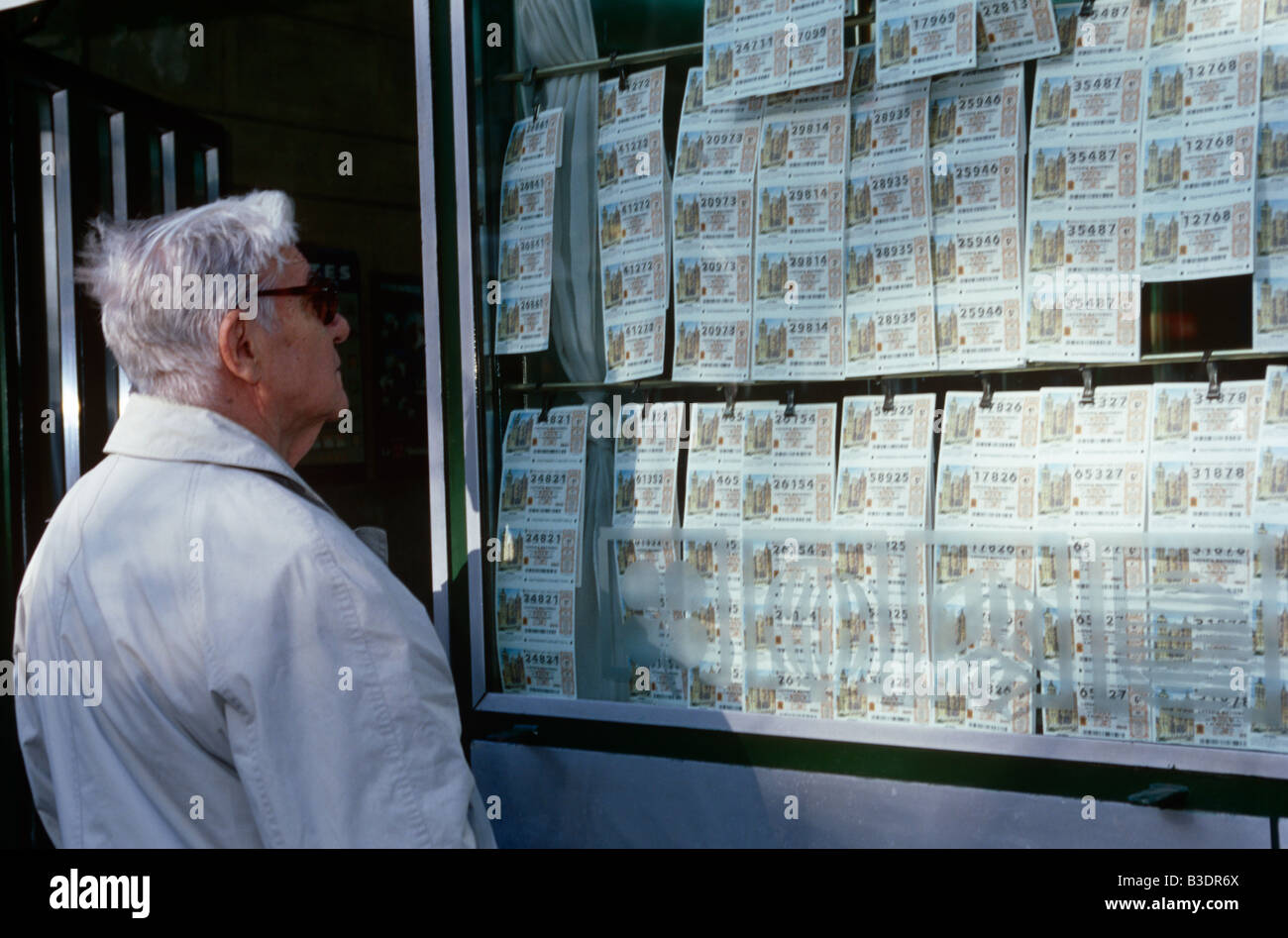 Uomo anziano scelta di biglietti della lotteria, Barcellona, Spagna Foto Stock