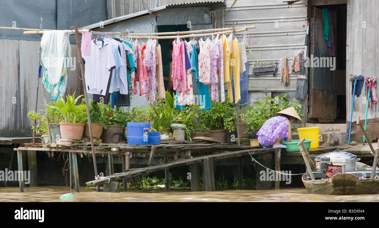 Una donna che lavora nella sua casa galleggiante nel Vietnam del Sud Foto Stock