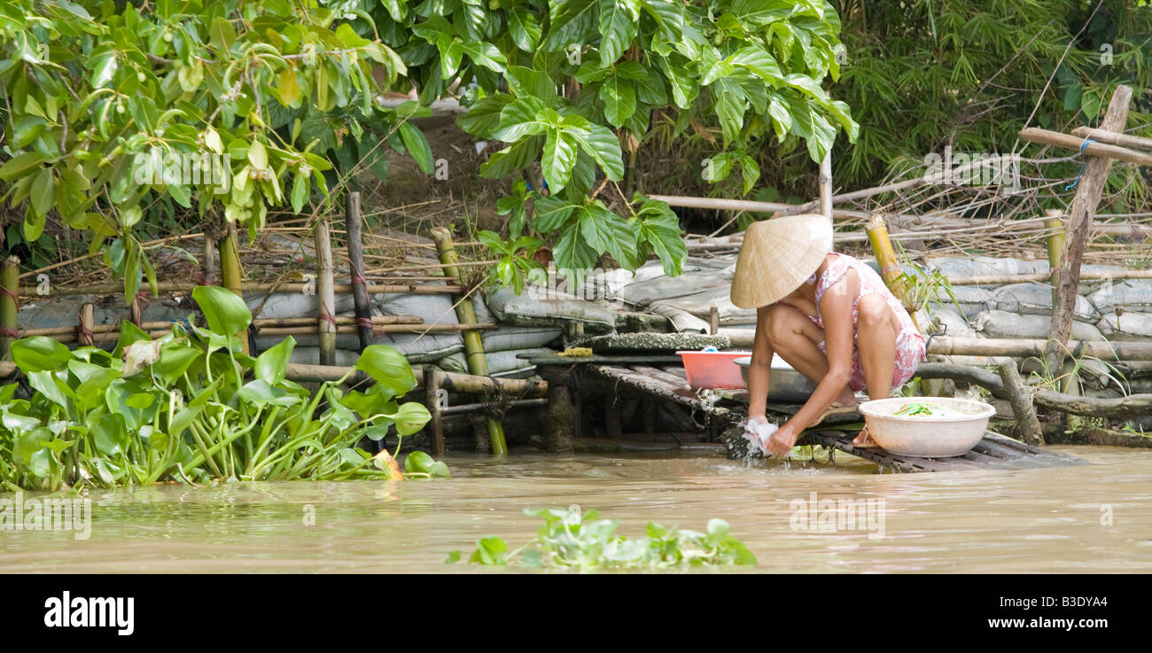 Una donna vietnamita per la pulizia e la preparazione del cibo nel Delta del Mekong, Vietnam Foto Stock