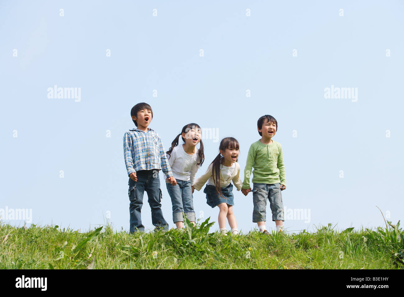 I bambini in piedi in una fila e urlare insieme Foto Stock