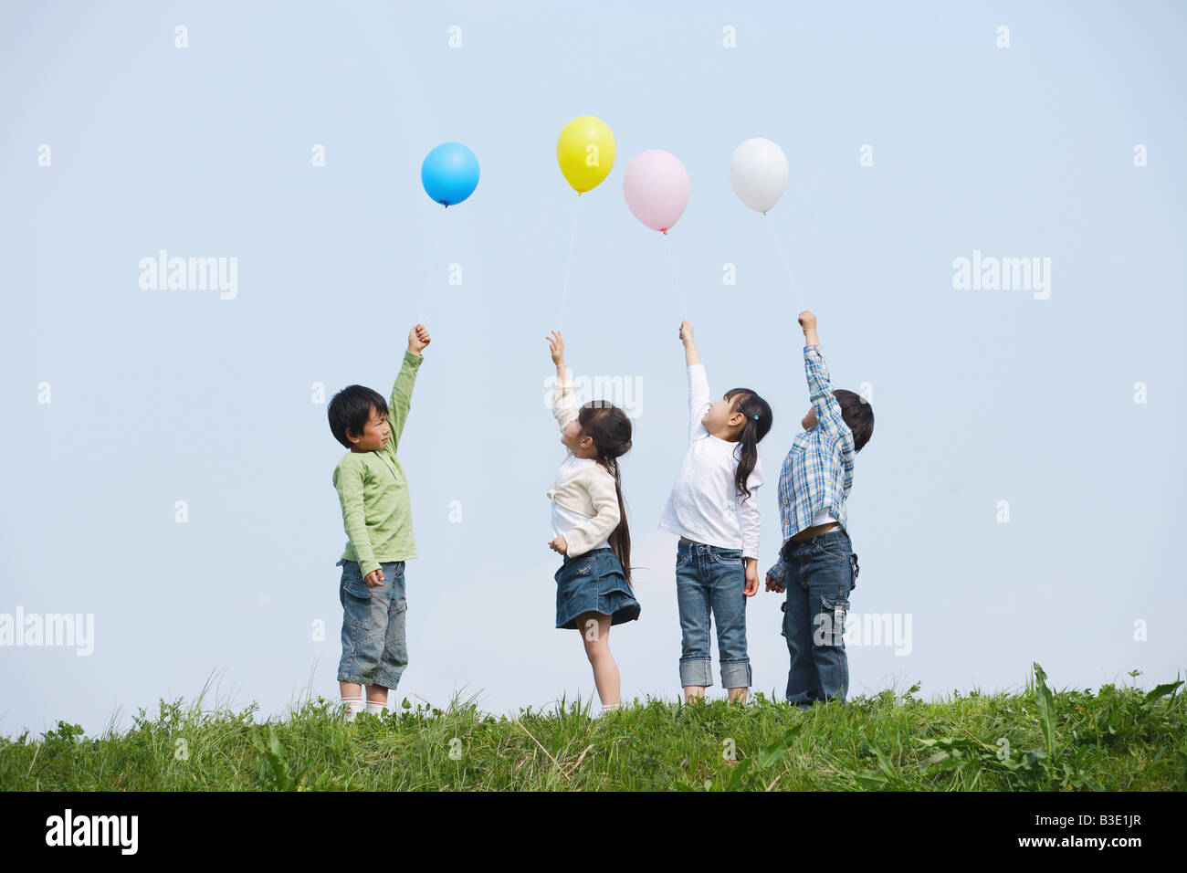 Bambini azienda palloncini colorati in posizione di parcheggio Foto Stock