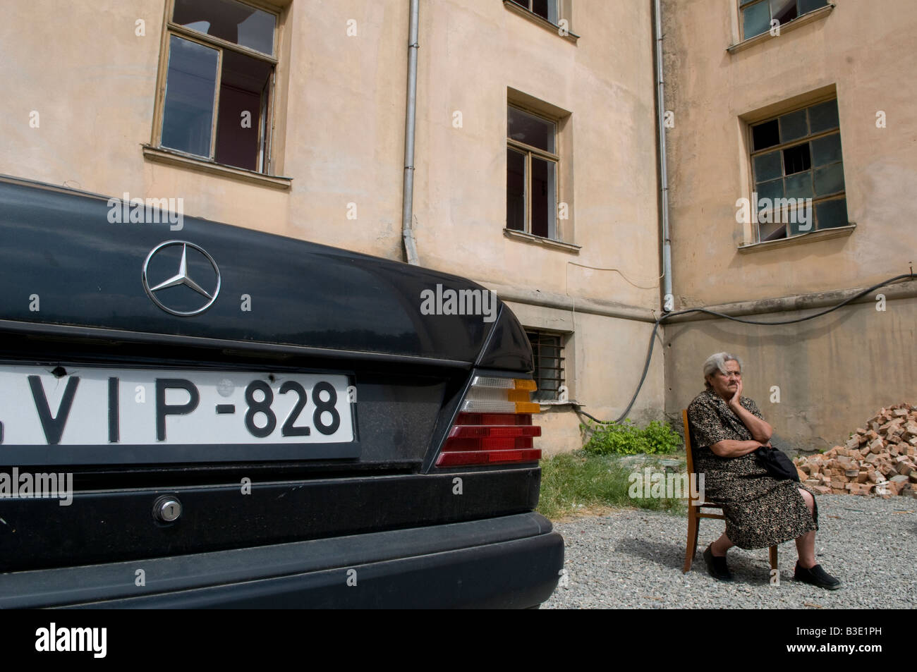 Una donna georgiana sembra sconvolta mentre siede accanto ad un edificio con finestre infrante nella città di Gori durante la guerra russo-georgiana agosto 2008 Foto Stock