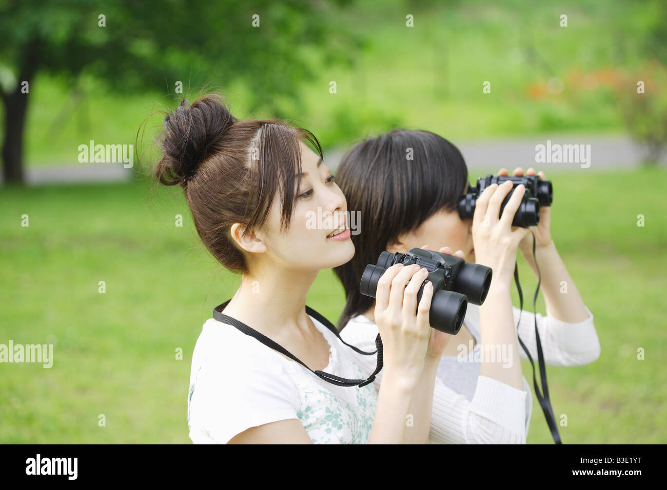 Giovani donne alla ricerca attraverso il binocolo Foto Stock