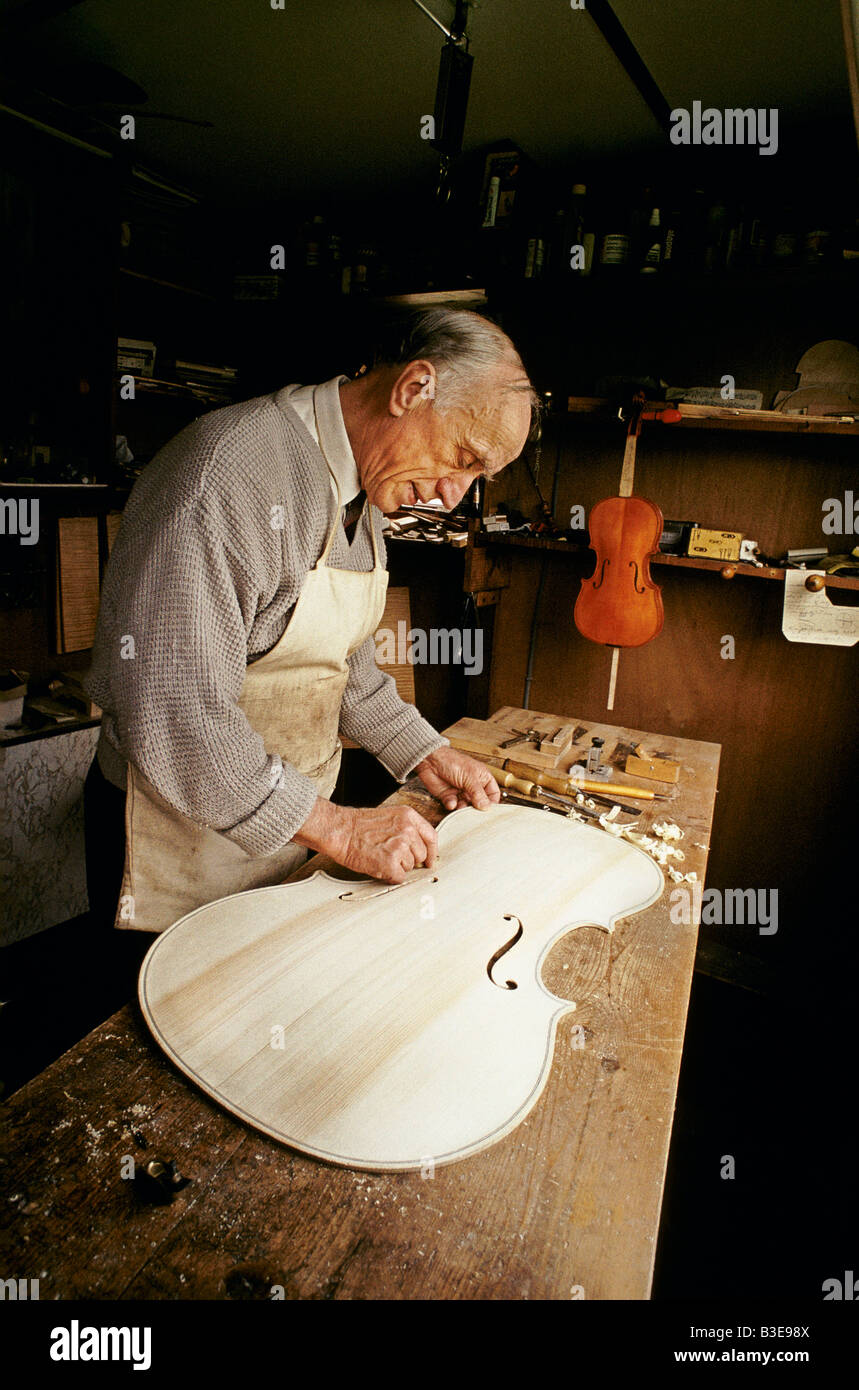 Un uomo che fa un violoncello con metodi tradizionali Foto Stock