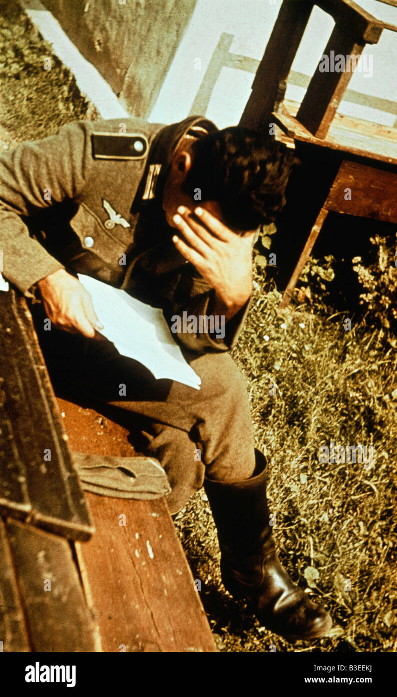 Soldato tedesco che legge una lettera / DURANTE LA SECONDA GUERRA MONDIALE Foto Stock