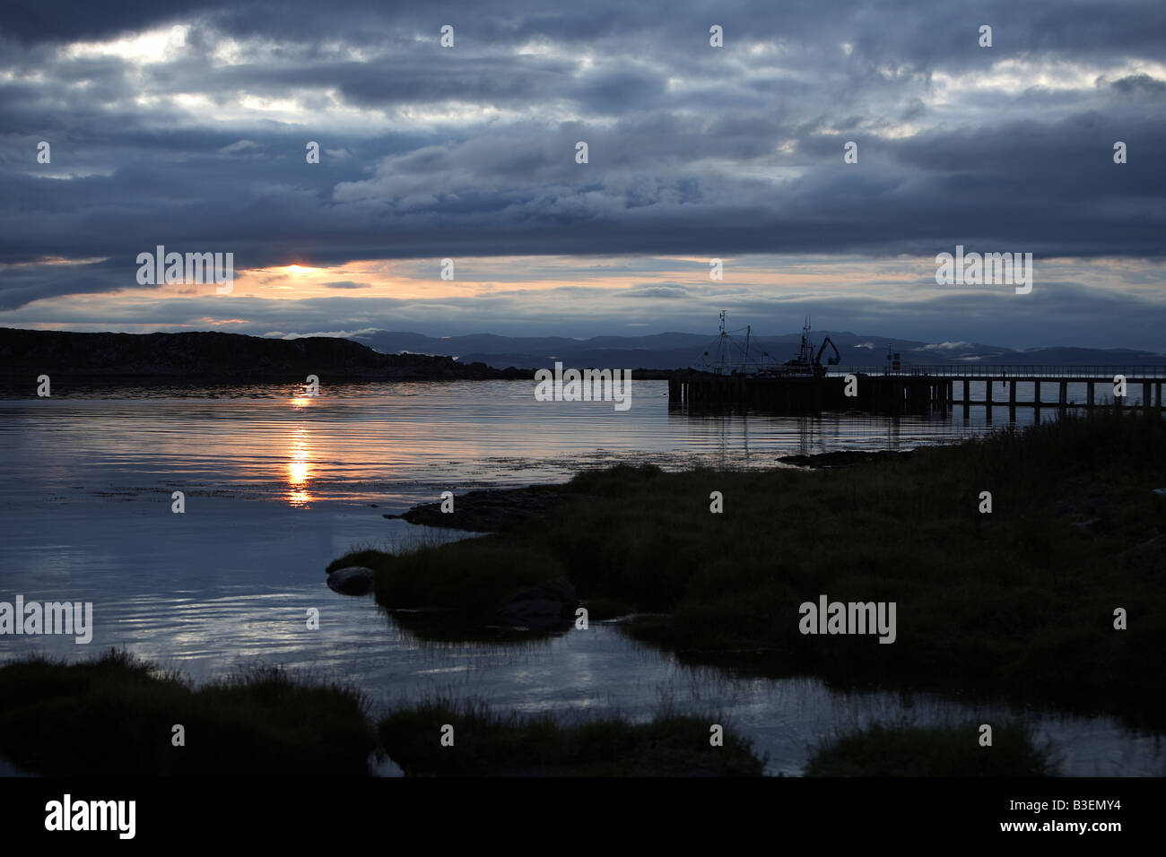 Sunrise oltre le piccole isole e pier a Craighouse Isle of Jura Ebridi Interne in Scozia UK Foto Stock