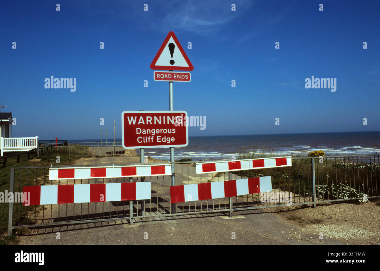 Blocco stradale cartello segnaletico di erosione costiera e la scomparsa di strada a Barmston costa orientale dello Yorkshire Regno Unito Foto Stock