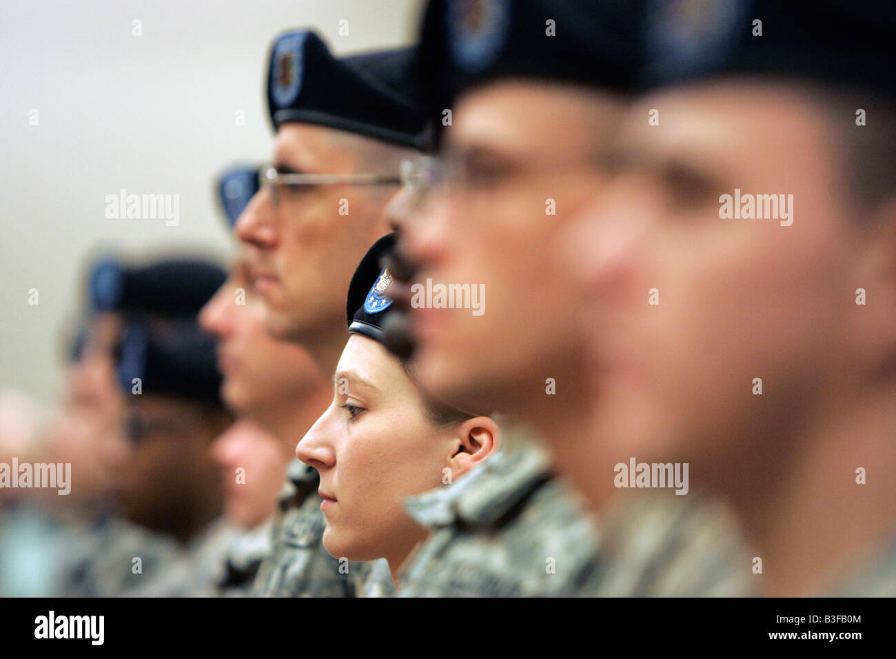 Un soldato di sesso femminile si erge a attenzione nella formazione durante un militare cerimonia di distribuzione Foto Stock