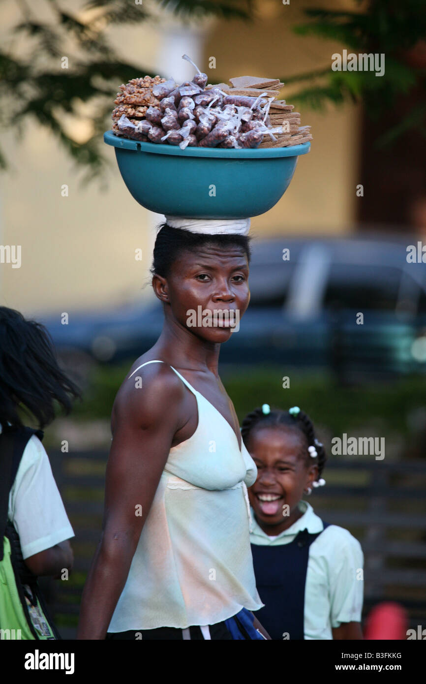 Donna dominicana portando un bacino di dolci al suo capo in Santo Domingo, Repubblica Dominicana Foto Stock