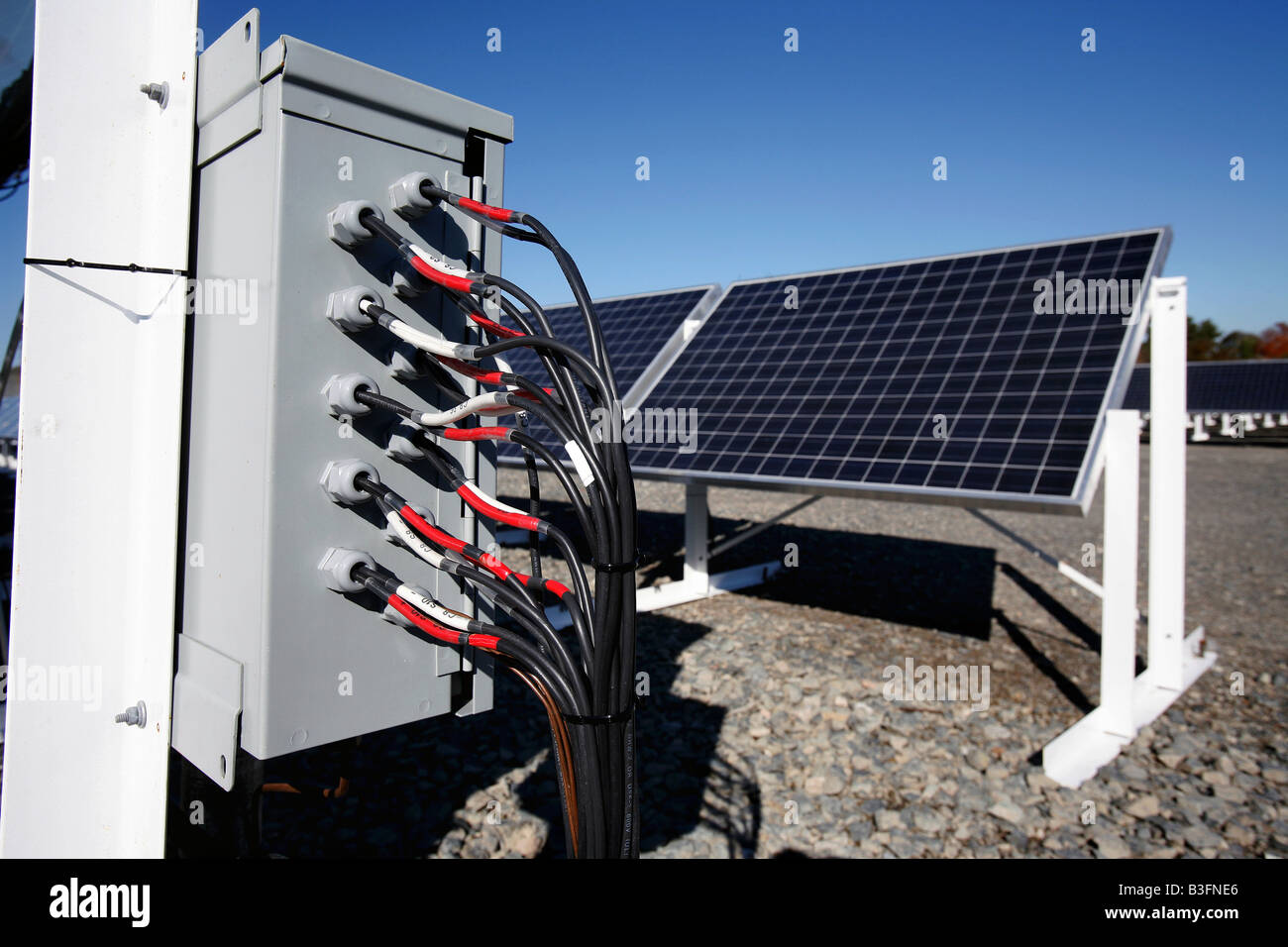 I fili elettrici immettere una scatola di giunzione sul sito di un solare di generazione di elettricità in array Brockton Massachusetts Foto Stock