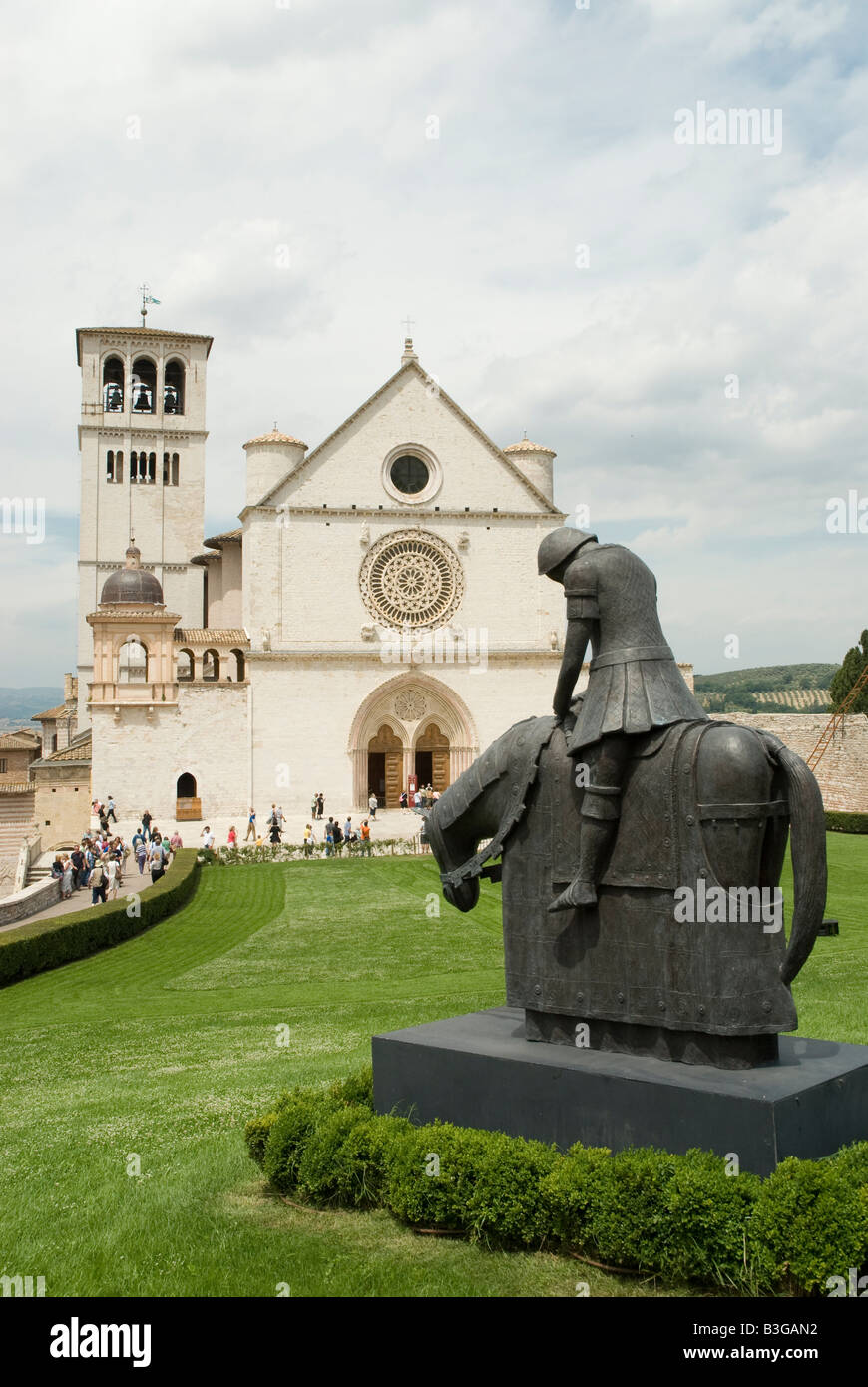 Basilica di San Francesco ad Assisi con la scultura in bronzo di San Francesco Cavalier Foto Stock