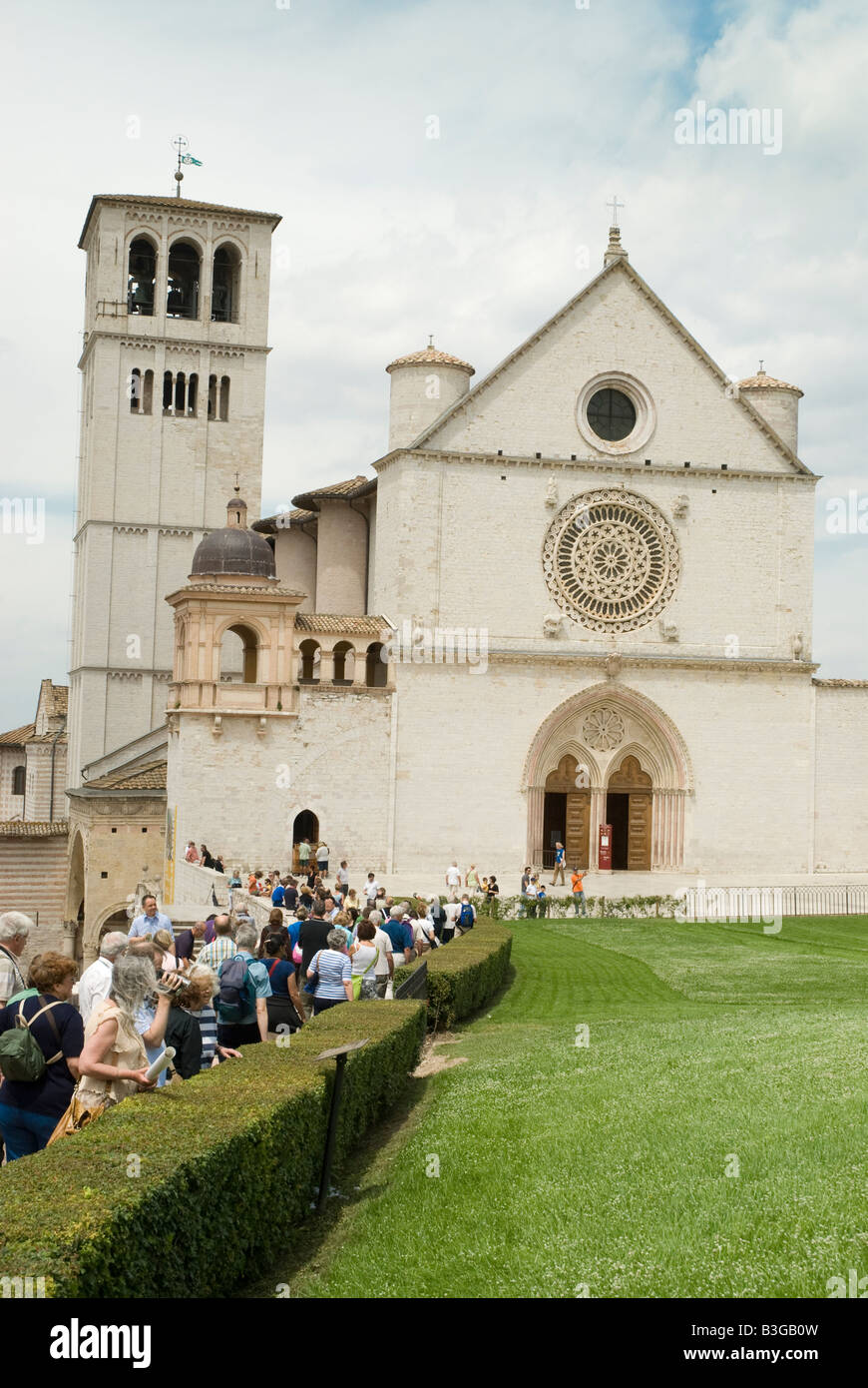 Basilica di San Francesco ad Assisi. Il monastero francescano (Sacro Convento) e la parte inferiore e la chiesa superiore (Basilica inferiore e superiore) di San Francesco furono iniziati subito dopo la sua canonizzazione nel 1228. Simone di Pucciarello ha donato la terra per la Chiesa, una collina sul lato ovest di Assisi, noto come 'Collina dell'Inferno" (it. Collo d'Inferno - qui i criminali sono state messe a morte). Oggi, questa collina è appropriatamente chiamato 'Collina del Paradiso". Foto Stock