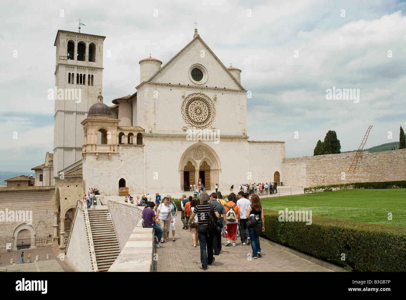 Basilica di San Francesco ad Assisi. Il monastero francescano (Sacro Convento) e la parte inferiore e la chiesa superiore (Basilica inferiore e superiore) di San Francesco furono iniziati subito dopo la sua canonizzazione nel 1228. Simone di Pucciarello ha donato la terra per la Chiesa, una collina sul lato ovest di Assisi, noto come 'Collina dell'Inferno" (it. Collo d'Inferno - qui i criminali sono state messe a morte). Oggi, questa collina è appropriatamente chiamato 'Collina del Paradiso". Foto Stock