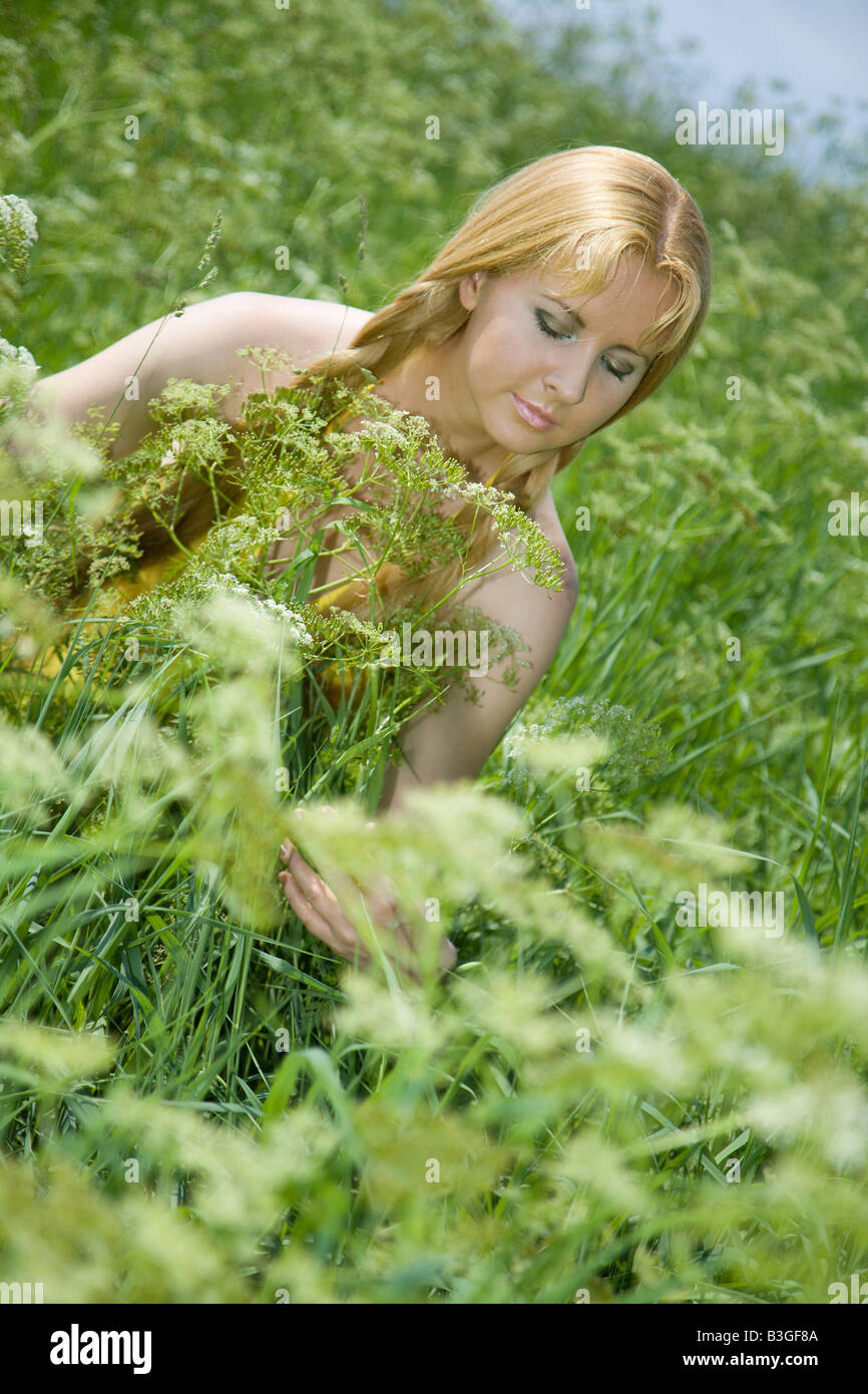 Bellezza ragazza soggiorno in erba alta Foto Stock