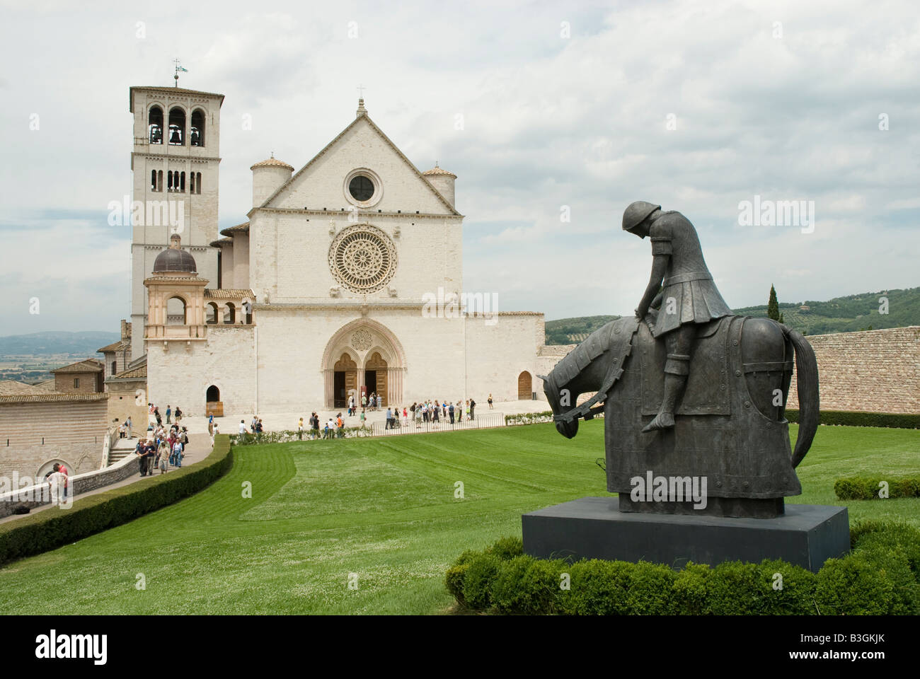 Basilica di San Francesco ad Assisi con la scultura in bronzo di San Francesco Cavalier Foto Stock