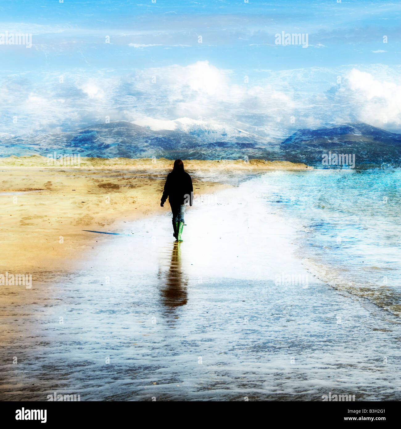 La solitudine di una giovane donna su una spiaggia Foto Stock