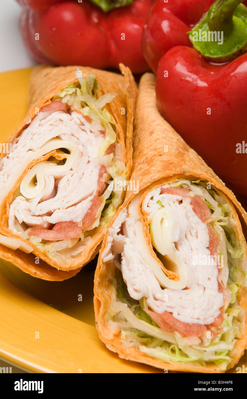 La Turchia e il formaggio svizzero avvolgere sandwich con peperoni rossi Foto Stock