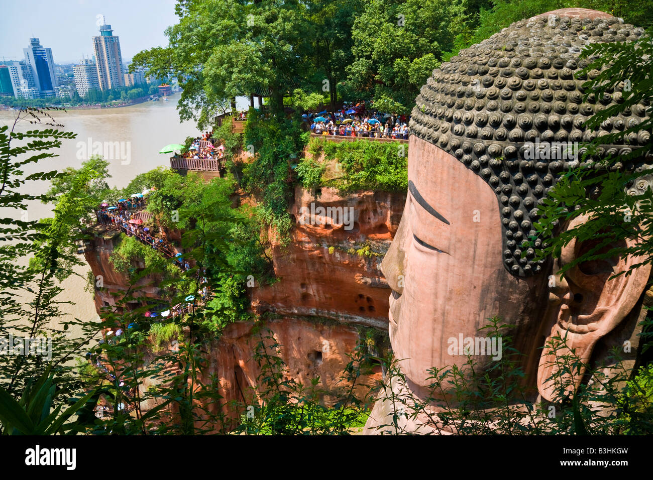 Buddha di Leshan Dafo nella provincia del Sichuan in Cina con Leshan city città sul fiume in background JMH3236 Foto Stock