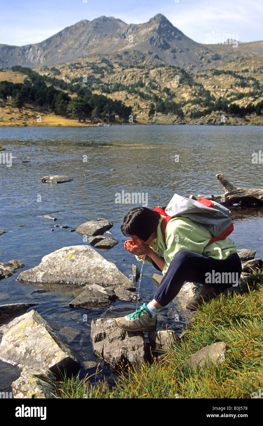 Donna accovacciata sul lago. Massiccio del Carlit. Pyrenees-Orientales. La Francia. L'Europa. Foto Stock