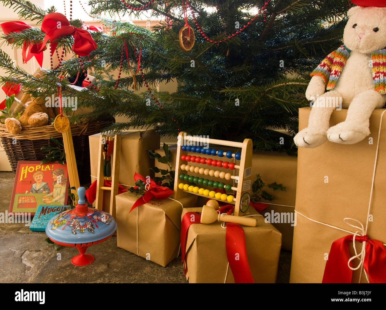 Una selezione dei bambini del vecchio regali di Natale sotto un albero di Natale decorato in uno stile Vittoriano Foto Stock