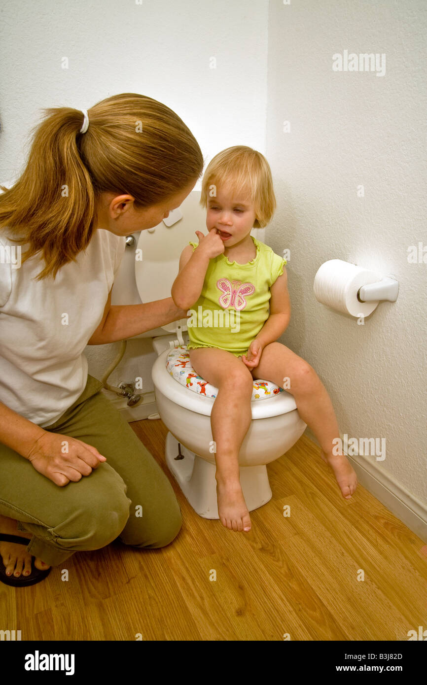 Una madre introduce la sua figlia di due anni di formazione igienica a casa nel sud della California Foto Stock