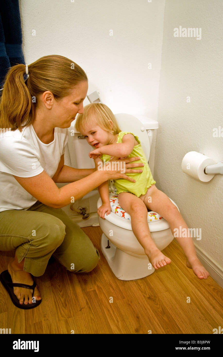 Una madre introduce la sua figlia di due anni di formazione igienica a casa nel sud della California Foto Stock