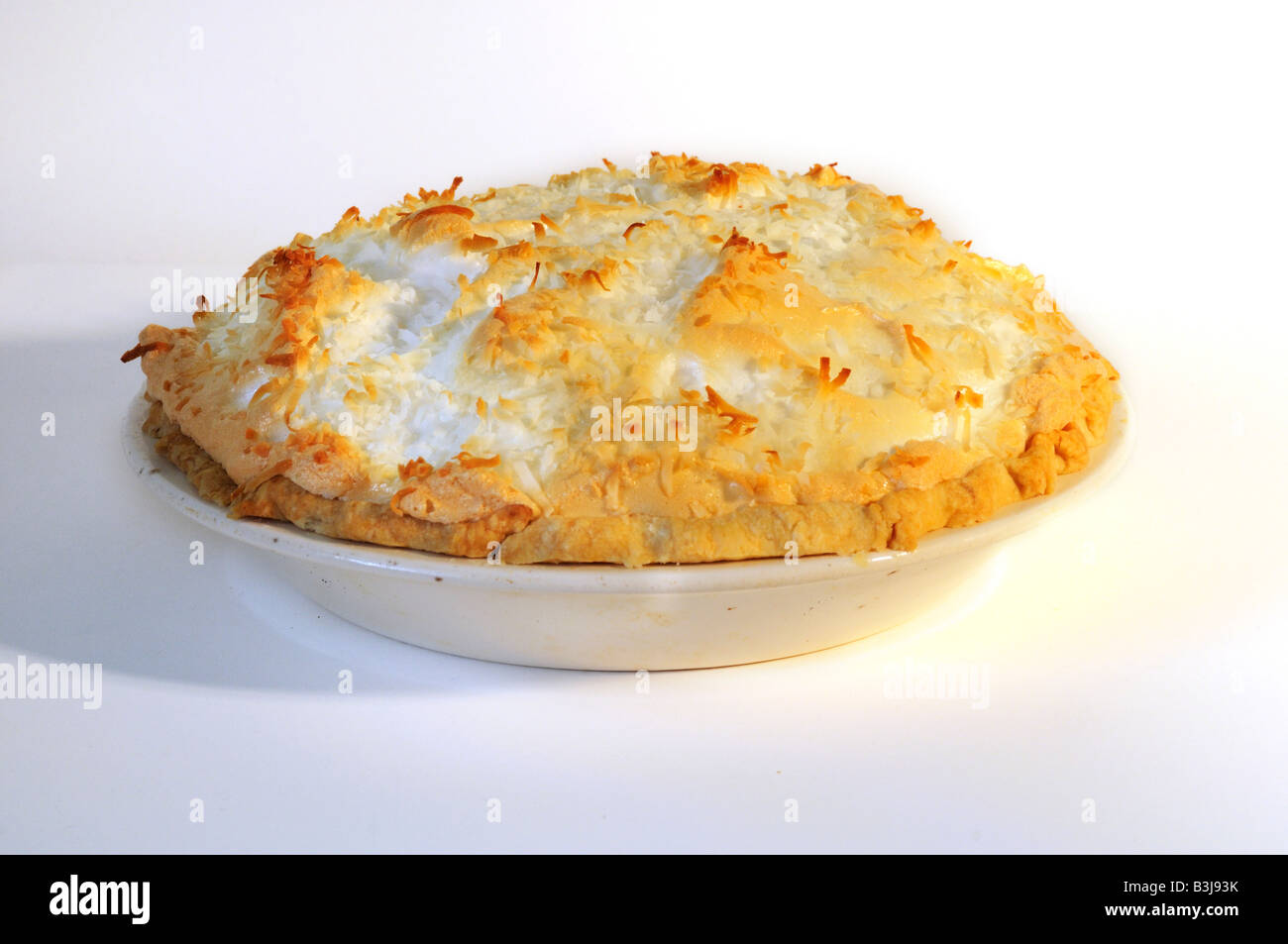Una noce di cocco intera Torta di crema su uno sfondo bianco. Intaglio Foto Stock