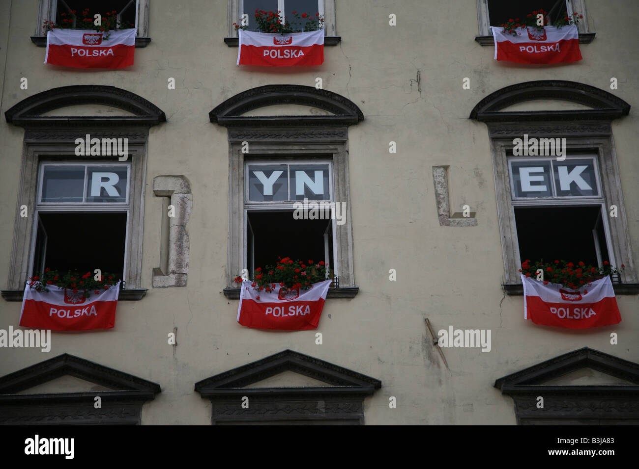 Bandiere polacche pendenti da costruire nella piazza principale del mercato,Rynek,Cracovia,Polonia Foto Stock