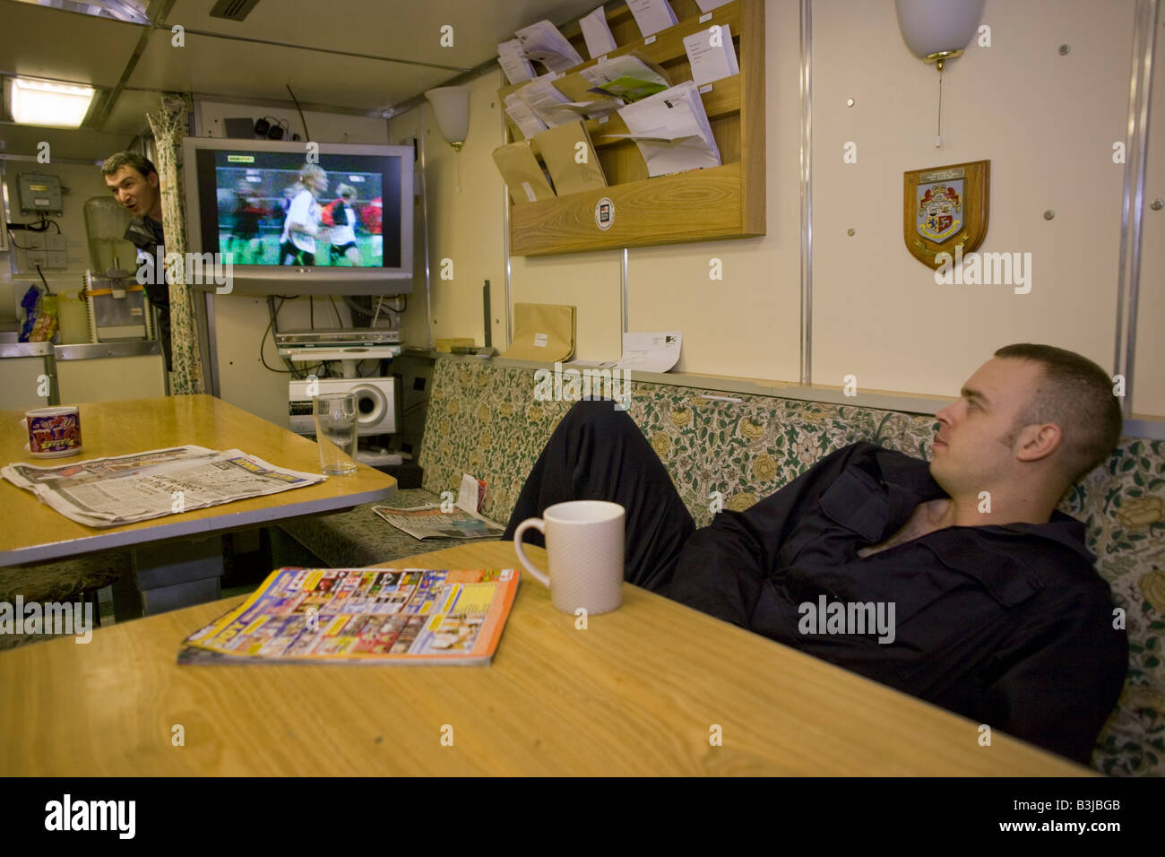 Royal Navy crewman guardano la televisione nella Junior valutazioni quadrato di poppa a bordo HMS vigili, un britannico classe Vanguard sottomarino nucleare Foto Stock