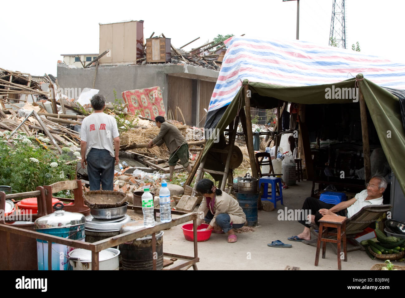 Famiglia nella tenda di fortuna al di fuori della loro casa distrutta dal terremoto del 12 maggio 2008 nel Sichuan, in Cina Foto Stock