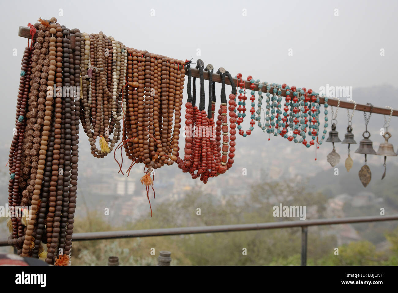 Perle e gioielli pendenti da uno stallo al tempio delle scimmie a Kathmandu, Nepal domina la valle. Foto Stock