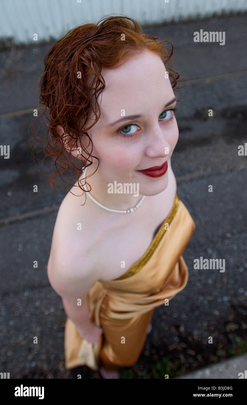 Ritratto di una ragazza che indossa un giallo abito da sera in un ambiente industriale Foto Stock