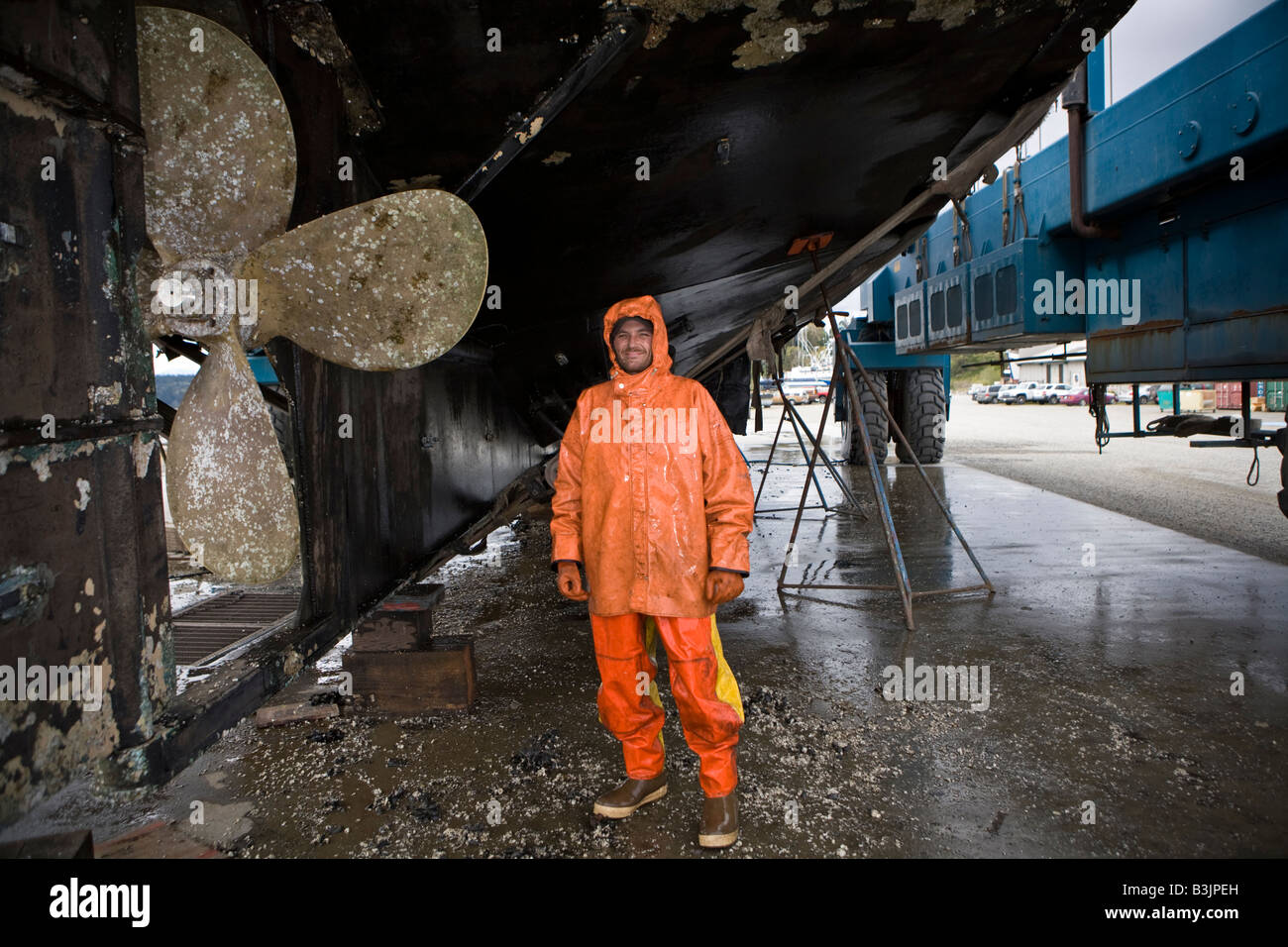 Robert Palmer lavaggi a pressione la parte inferiore di un 88 piedi lungo la pesca in barca Leann nel cantiere navale di Port Townsend Foto Stock
