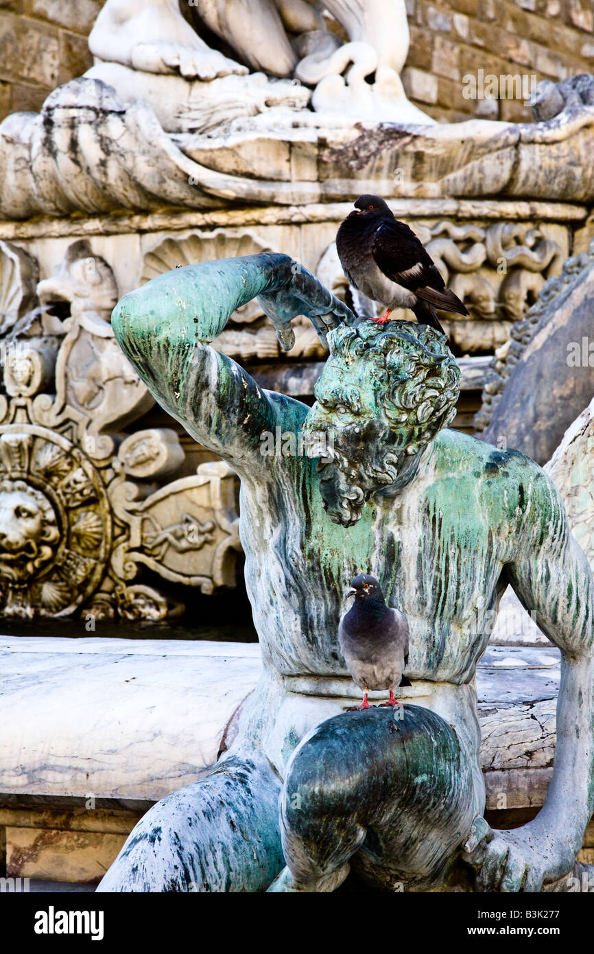 Piccioni seduti su uno dei lati di sculture sulla Fontana di Nettuno dell'Ammannati Foto Stock