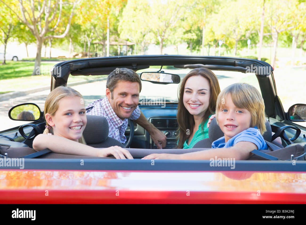 Famiglia in autovettura convertibile sorridente Foto Stock