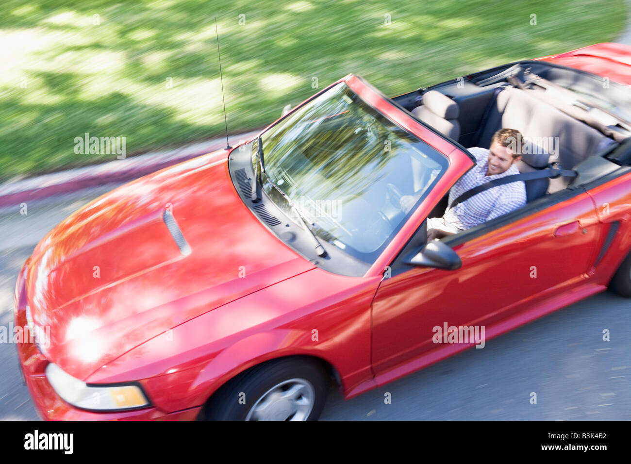 Uomo alla guida di autovettura convertibile sorridente Foto Stock