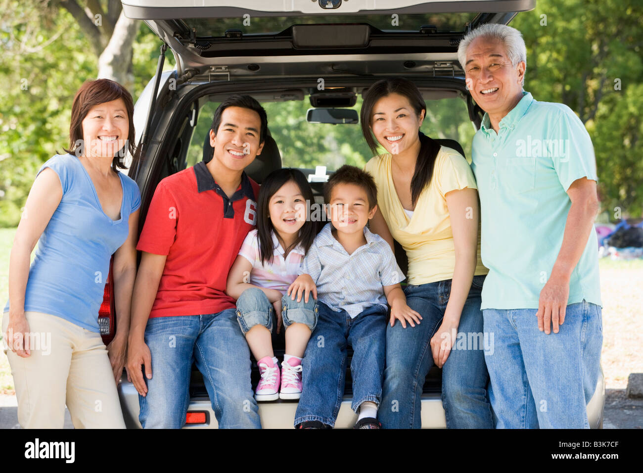 Famiglia estesa in seduta il portellone della vettura Foto Stock